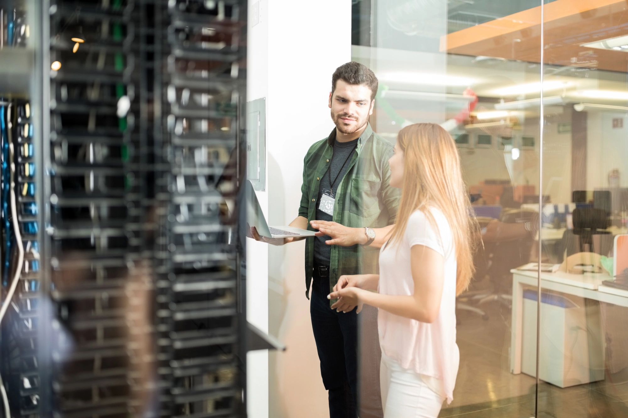 Two people discussing in a server room.