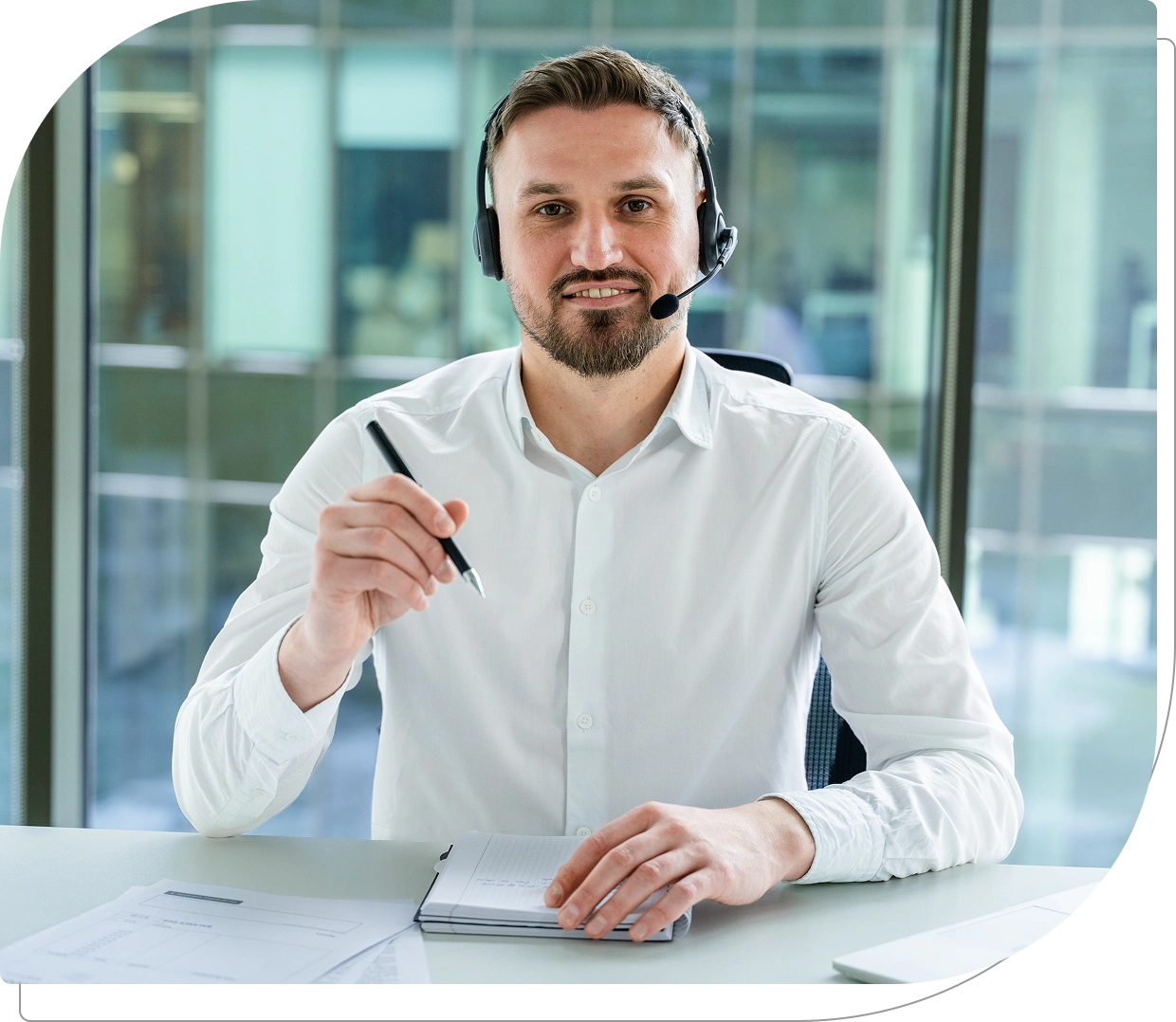 Man with headset sitting at office desk.